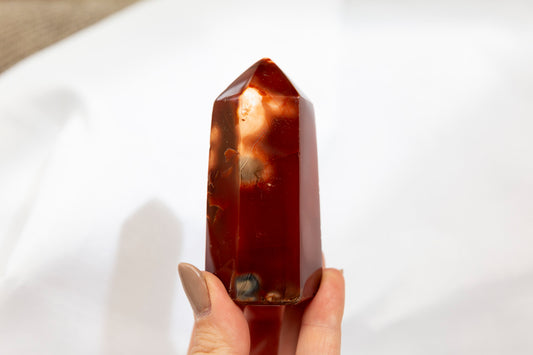 Hand holding a red crystal on a white background