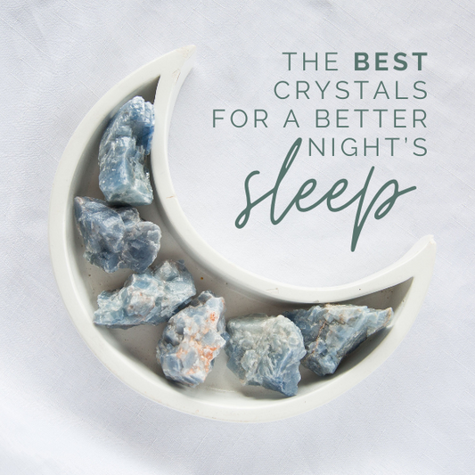 Blue calcite crystals in a white crescent moon shaped dish on a white background with the text 'the best crystals for a better night's sleep'