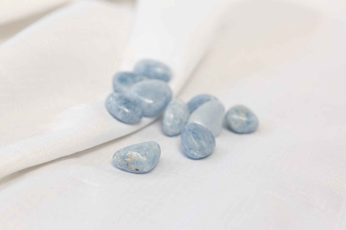 Blue calcite tumblestones on a white surface