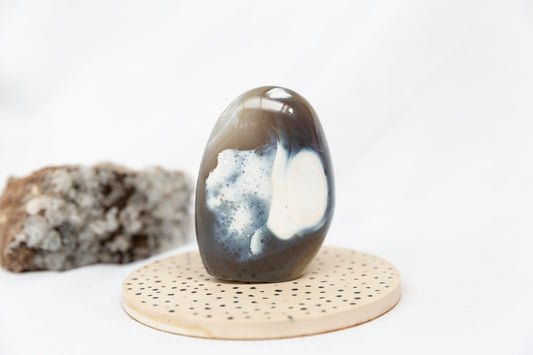 Orca Agate Freeform on a spotted coaster against a white background